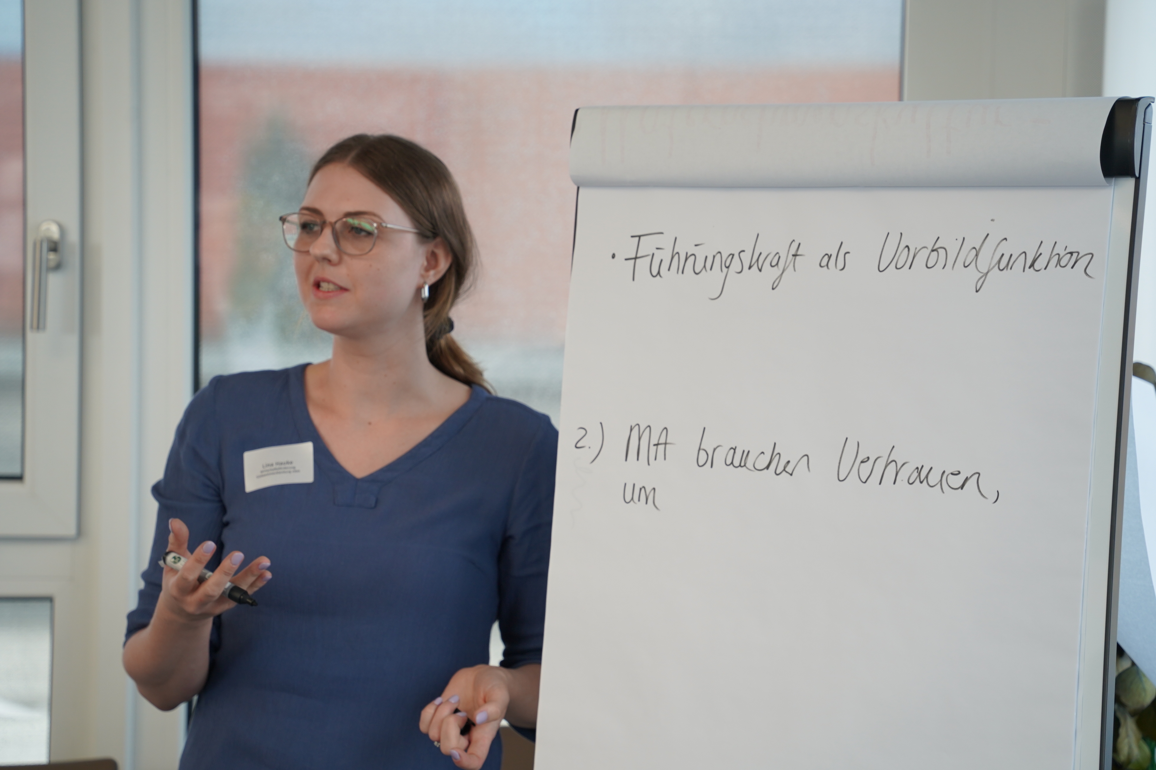 Eine Frau steht vor einem Flipchart.
